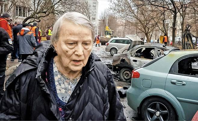 25일 우크라이나 하르키우에서 한 주민이 이틀 전 러시아의 드론 공습으로 파손된 차량들 사이를 지나가고 있다. /로이터