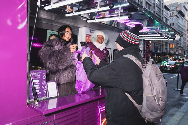 LG생활건강 두피케어 브랜드 닥터그루트 미국 뉴욕 팝업 트럭 행사에서 인플루언서 브랫맨 락이 제품을 증정하고 있다. /LG생활건강 제공