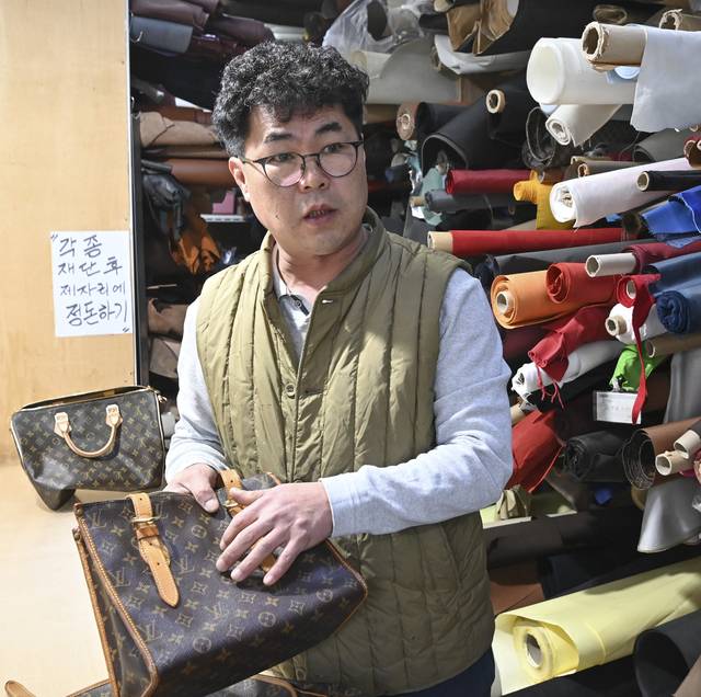 이경한 강남사 대표가 지난 12일 서울 강남구 압구정로 작업실에서 루이비통 핸드백을 들어 보이며 루이비통과의 상표권 침해 소송이 어떻게 진행됐는지 설명하고 있다.  백동현 기자