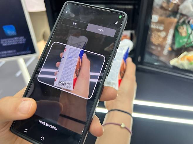 가민 커넥트 플러스 존에서 현장 관계자의 안내에 따라 스마트폰을 들고 단백질 음료의 바코드를 촬영하는 모습. [박혜림 기자/rim@]