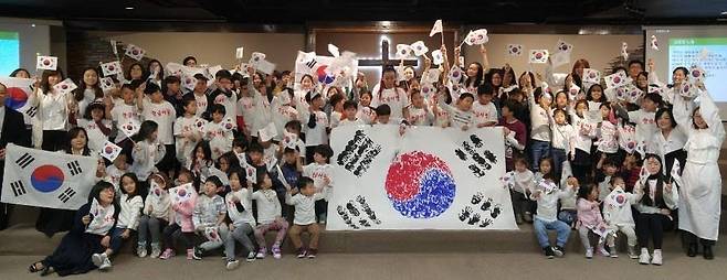 삼일절 기념행사 갖는 댈러스 한국학교 학생들  삼일절을 맞아 댈러스 한국학교 학생들이 손도장으로 만든 태극기를 들고 만세삼창을 하고 있다. [재미한국학교협의회 제공]