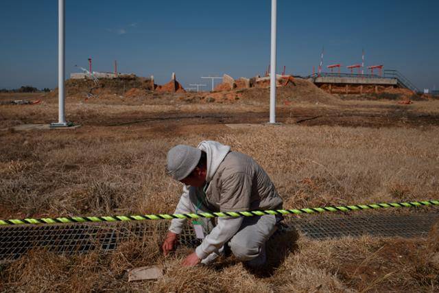 참사로 아내와 딸을 잃은 김성철(54)씨가 3월 20일 무안국제공항 활주로 로컬라이저 인근에서 직접 유해 추정 물체를 발견하고 위치를 표시하고 있다. 무안=하상윤 기자