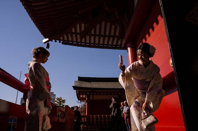 지난해 11월 기모노를 입은 중국인 관광객들이 일본 도쿄 아사쿠사 지역 센소지를 방문해 기념사진을 찍고 있다. / 사진 : 도쿄=AP/뉴시