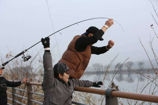 참가자들이 낚싯대를 더 멀리 던지기 위해서 힘을 모으고 있다.