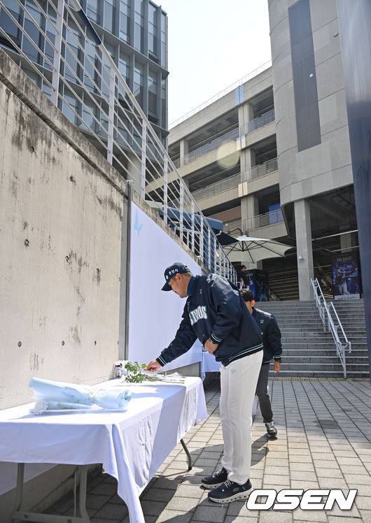 [OSEN=창원, 이석우 기자] 29일 창원NC파크에서 2026 신한 SOL KBO 리그 NC 다이노스와 두산 베어스의 경기가 열린다. NC 다이노스 야구단이 1년전 창원NC파크 외벽 구조물 추락 사망 사고 1주기 추모행사를 열었다. NC 다이노스 이호준 감독이 희생자의 명복을 빌며 헌화하고 있다. 2026.03.29 / foto0307@osen.co.kr