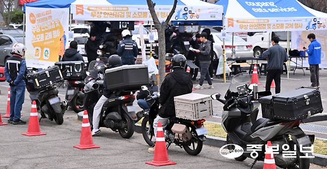 30일 오전 수원시 장안구 수원종합운동장 주차장에서 열린 '이륜차 사고 예방과 친환경 운행을 위한 무상 안전 점검 및 소모품 교체 행사'에서 관계자들이 오토바이를 점검하고 있다. 김경민기자