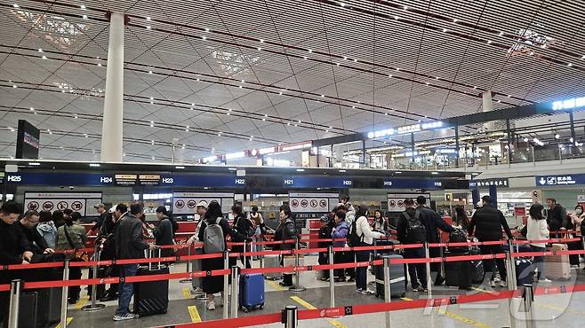 30일 오전 중국 베이징 서우두공항 제3터미널에서 베이징~평양 노선을 포함한 주요 국제선 노선 탑승 수속 카운터에 사람들이 줄을 서 있다. ⓒ 뉴스1 정은지 특파원