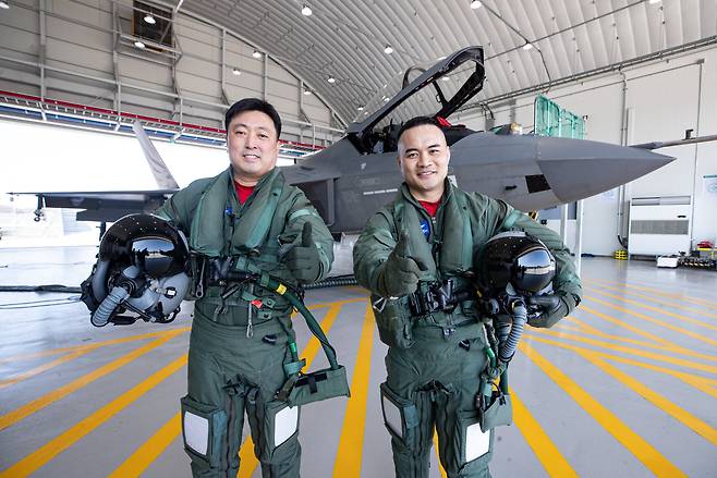 경남 사천 한국항공우주산업(KAI)에서 만난 시험비행조종사 안준현(왼쪽), 전승현 중령. 제281 시험비행대대 전현직 대대장이기도 한 이들이 국산 초음속 전투기 KF-21 앞에서 대대 구호인 '우리가 처음이다'를 외치고 있다. /김동환 기자