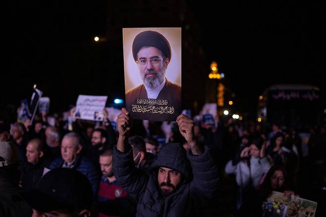레바논 베이루트에서에서 열린 집회에 참석한 남성이 이란의 신임 최고 지도자 모자타바 하메네이(Mojtaba Khamenei)의 사진을 들고 있다. 로이터=연합뉴스