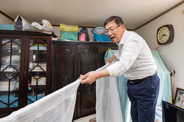 깅경호 광진구청장이 관내 어르신 집의 커튼을 달아주고 있다. 광진구청 제공
