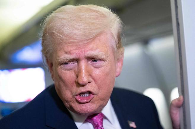 도널드 트럼프 미국 대통령이 29일(현지시간) 플로리다주에서 워싱턴DC로 복귀하는 대통령 전용기 안에서 취재진들과 약식 회견을 하고 있다. [AFP]