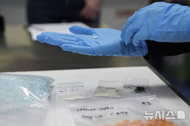 [샌디에이고=AP/뉴시스] 지난 3월 16일(현지 시간) 미국 캘리포니아 샌디에이고의 산이시드로 국경검문소를 방문한 크리스티 놈 미 국토안보부 장관이 펜타닐 정제를 살펴보고 있다. 2025.06.26.