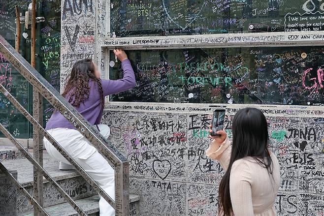 3월24일 서울 강남구 청구빌딩을 찾은 외국인 아미 (ARMY·BTS 팬덤)들이 BTS 멤버들이 연습생 시절 이용했던 옛 빅히트(하이브) 사옥 외벽에 낙서를 하고 있다. ⓒ시사저널 박정훈