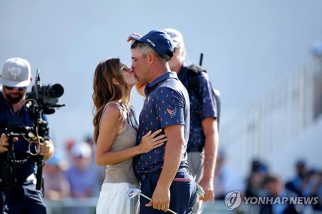 우승 확정 후 아내 개비(왼쪽)와 키스하는 우들런드 [로이터=연합뉴스] Mandatory Credit: Erik Williams-Imagn Images