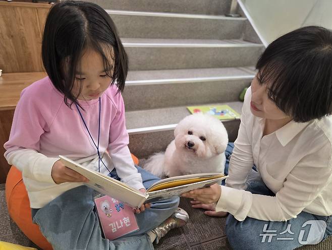 김나현 어린이가 리딩독 홀릭이에게 책을 읽어주고 있다. ⓒ 뉴스1 한송아 기자