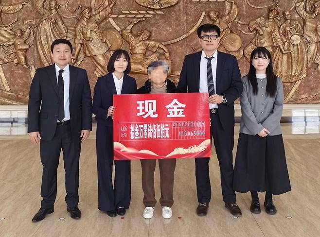 보이스피싱 피해자인 박모 씨(가운데)가 17일 중국에서 피해금 2400만 원을 돌려받은 뒤 경찰 관계자들과 기념촬영하고 있다. 강원경찰청 제공