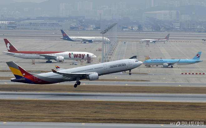 (인천공항=뉴스1) 박정호 기자 = 중동 사태로 국제유가와 환율이 오르면서 비용 부담이 커진 항공사들이 운항편을 줄이고 요금을 인상하는 등의 대책이 나오고 있는 가운데 30일 인천국제공항 계류장에 대기하는 항공기 앞으로 아시아나항공 항공기가 이륙하고 있다. 2026.3.30/뉴스1 Copyright (C) 뉴스1. All rights reserved. 무단 전재 및 재배포, AI학습 이용 금지. /사진=(인천공항=뉴스1) 박정호 기자