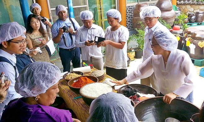 전북 순창군 고추장민속마을을 찾은 외국인 관광객들이 유네스코 인류무형문화유산에 등재된 한국의 전통 장 담그기 체험을 하고 있다. 순창군 제공