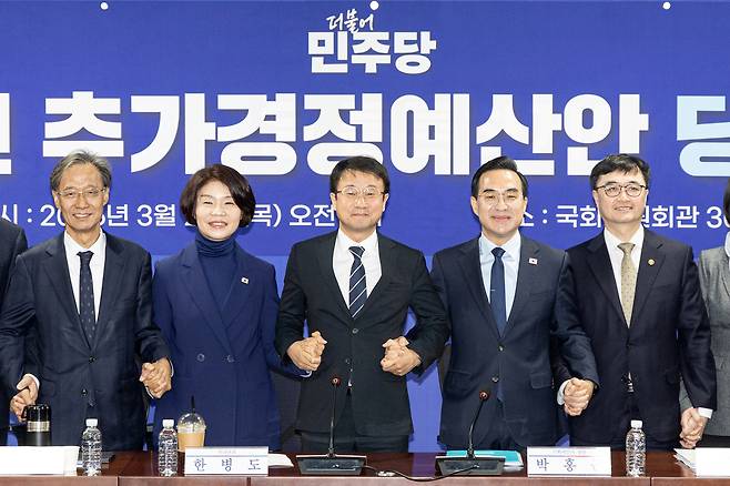 한병도(왼쪽 세 번째) 더불어민주당 원내대표가 3월 26일 서울 여의도 국회 의원회관에서 열린 2026년 추가경정예산안 당정협의회에서 박홍근(왼쪽 네 번째) 기획예산처 장관을 비롯한 참석자들과 기념촬영하고 있다. 뉴스1