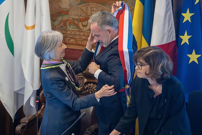 29일 프랑스 파리 시청에서 열린 취임식 시의회에서 도미니크 키엘레모스 파리 시의회 상임의원(왼쪽)이 신임 파리시장 에마뉘엘 그레고르(중앙) 지명 후 프랑스 국기 삼색 띠를 선물하고 있다. /연합뉴스