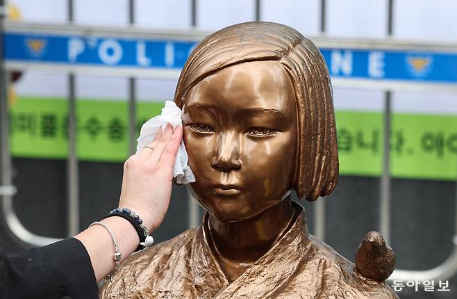 1일 서울 종로구 옛 주한 일본대사관 앞에서 열린 제1746차 일본군 성노예제 문제해결을 위한 정기 수요시위를 앞두고 한 정의연 활동가가 소녀상의 얼굴을 닦고 있다. 이한결 기자 always@donga.com