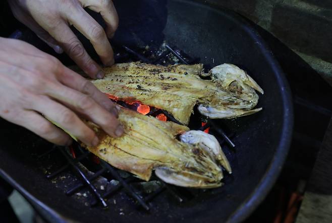 Euljiro's common snack, nogari, or dried, young pollock fish, is being cooked at a bar in the neighborhood.[JOONGANG ILBO]