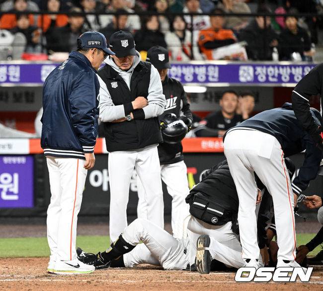 그라운드에 방문해 걱정스럽게 허경민 상태 살피는 이강철 감독-양상문 코치