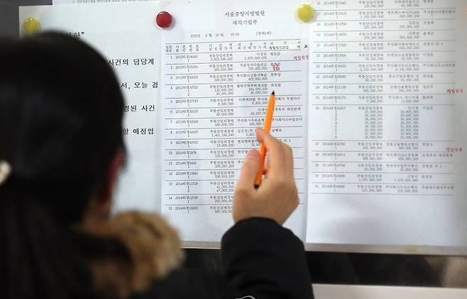 서울중앙지방법원 경매법정 앞에서 응찰 예정자가 게시물을 살피는 모습 [연합뉴스 자료사진. 재판매 및 DB 금지]