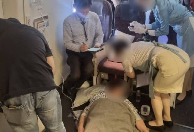 (지난달 24일 인천발 마닐라행 비행기에서 발생한 응급 환자를 치료하고 있는 교수. (사진=김정환 강남을지대병원 교수 SNS 캡처)