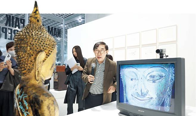 백남준 조카 하쿠다 켄이 ‘골드 TV 부처’(2005) 앞에서 작품 설명을 하고 있다. 금박 입힌 청동 불상이 모니터 앞에서 명상하는 이 작품은 백남준의 대표 연작 ‘TV 부처’의 후기작으로, 국내에서 처음 공개됐다. /연합뉴스