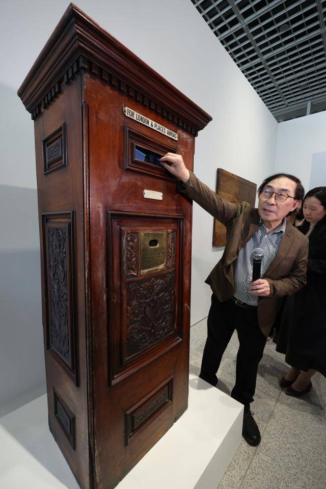 켄 백 하쿠타가 1일 서울 용산구 APMA 캐비닛에서 열린 '백남준 리와인드 리핏' 기자간담회에서 작품 '런던과 해외를 위해(우편함)'를 설명하고 있다. 우편함 내부에는 백남준이 미리 녹화한 비디오가 아닌 실제 한국의 생방송이 나온다. 뒤편에는 이 작품을 구매했던 김마태 박사의 이름이 백남준 자신의 서명과 함께 적혀 있다. 연합뉴스