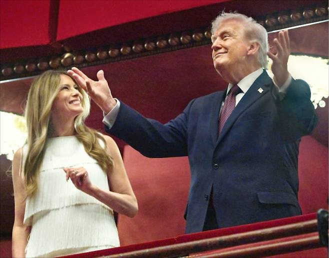 <전쟁 중에 뮤지컬 즐기는 트럼프>
미국 워싱턴DC와 이란 테헤란은 약 1만180㎞ 떨어져 있다. 전쟁 중인 두 나라의 모습은 이 거리를 사이에 두고 극명하게 엇갈렸다. 도널드 트럼프 미국 대통령과 부인 멜라니아는 31일(현지시간) 워싱턴DC 존F케네디공연예술센터에서 뮤지컬 ‘시카고’ 개막 공연을 관람했다(왼쪽 사진). 미국의 공습으로 전력이 끊겨 암흑에 잠긴 테헤란에선 한 시민이 다친 가족을 안고 대피하고 있다.  AFP·UPI연합뉴스