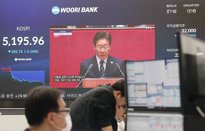 A broadcast of President Lee Jae Myung’s address at the National Assembly on a supplementary budget related to the conflict in the Middle East is shown on a dealing room board at Woori Bank’s headquarters in Jung District, central Seoul, on April 2. [YONHAP]
