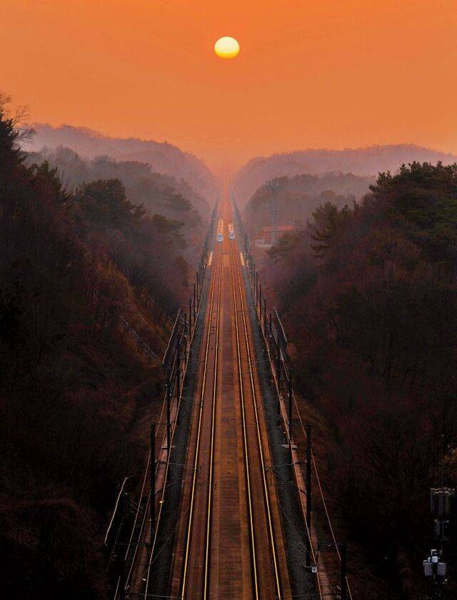 저물녘 경북 경산시 진량읍 현내리 현안터널 위에서 바라본 KTX 경부선. 주황빛 레일이 ‘은하철도’를 연상시킨다.