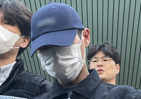 장모를 때려 숨지게 한 뒤 캐리어에 시신을 담아 유기한 혐의로 긴급체포된 20대 사위가 2일 대구 북부경찰서에서 법원 영장실질심사를 받기 위해 이동하고 있다. [연합뉴스]