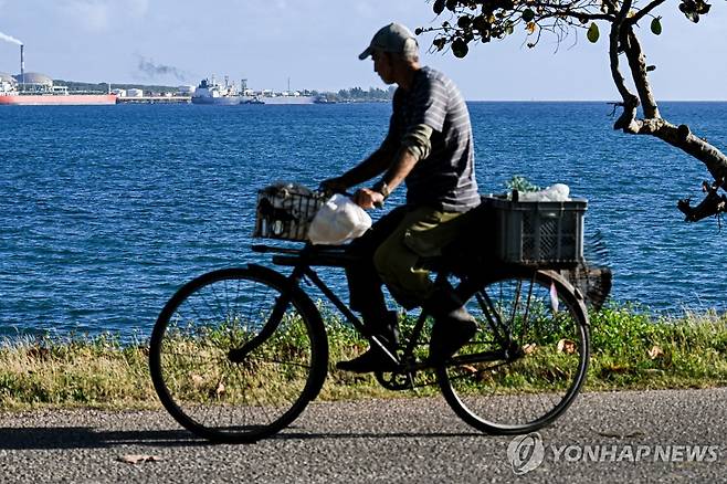 "신의 선물"이라 불리는 쿠바의 바다를 보며 자전거를 타는 남성 [AFP=연합뉴스]