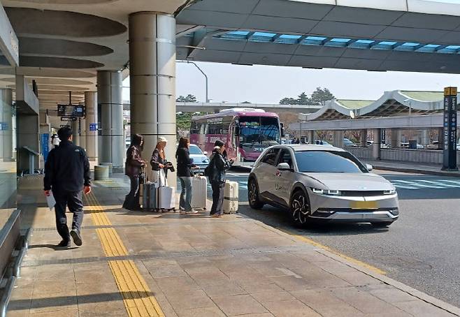 2일 오전 11시께 김포공항 국제선 앞 버스정류장 주변에서 여행객들이 예약택시를 타려고 줄 서 있다. (사진= 이종일 기자)