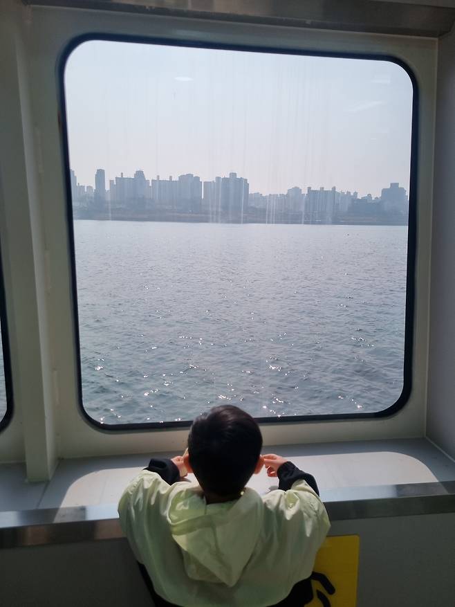 지난 28일 서울 여의도 선착장에서 출발해 마곡 선착장으로 향하는 한강버스에서 아이가 외부 풍경을 보고 있다. /김양혁 기자