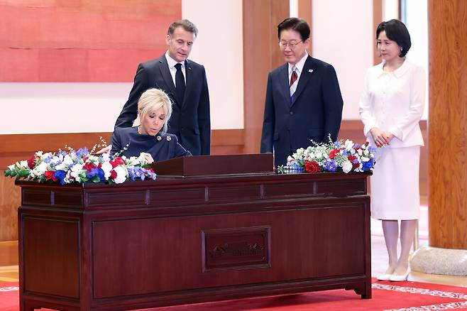 이재명 대통령과 김혜경 여사가 3일 청와대에서 에마뉘엘 마크롱 프랑스 대통령에 이어 방명록을 작성하는 브리지트 마크롱 여사를 지켜보고 있다. ⓒ연합뉴스