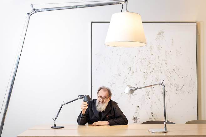 미켈레 데 루키가 ‘톨로메오’ 제품들에 둘러싸인 채 포즈를 취했다. 1987년 데스크 램프로 출시된 톨로메오는 스탠드형 거실 램프, 천장 조명 등 다양한 크기와 용도로 변주되며 전 세계적으로 2000만개 이상 판매됐다./장은주 영상미디어 객원기자