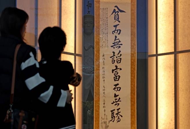 안중근 의사 유묵 특별전 `우리, 다시 안중근을 마주하다\'가 순국 116주기인 2026년 3월26일 오전 서울 중구 안중근의사기념관에서 열려 관람객이 ‘빈이무첨 부이무교\'라고 적힌 안 의사의 유묵을 보고 있다. 안 의사의 동상이 반사돼 보인다.