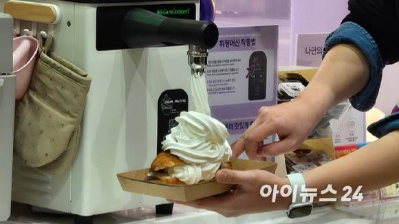 CU 성수디저트파크점에 비치된 휘핑크림 디스펜서를 통해 나만의 디저트를 만들고 있다. [사진=아이뉴스24 DB]
