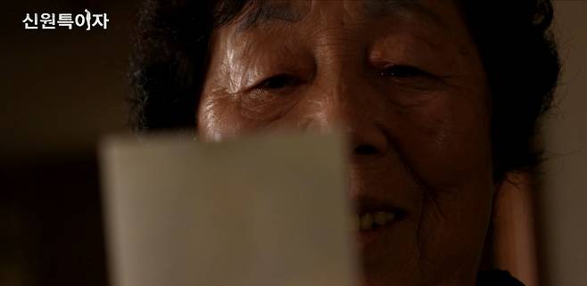 남편 오용승 씨의 사진을 바라보고 있는 문명은 씨.