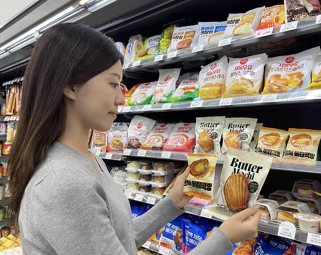 GS25에서 출시한 쫀득버터떡빵과 마들렌모양버터모찌 상품을 살펴보고 있다. (GS리테일 제공)