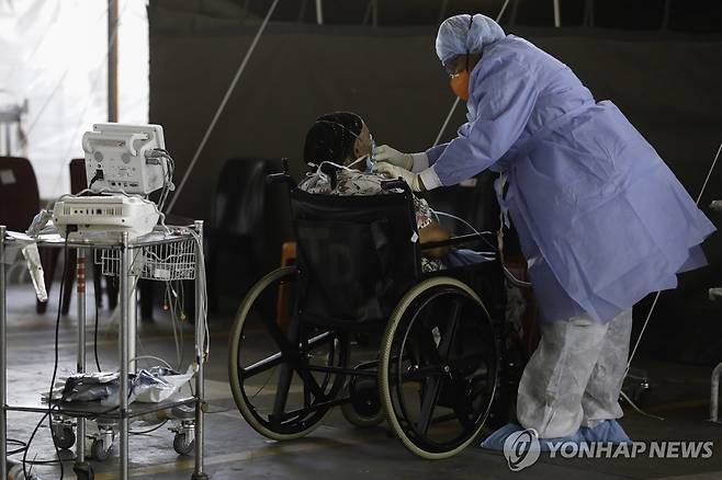 2021년 1월 코로나19 팬데믹 시기에 남아프리카공화국 프리토리아에 있는 스티브 비코 학술 병원에서 의료진이 환자를 살펴보고 있다. [EPA=연합뉴스 자료사진. 재판매 및 DB 금지]