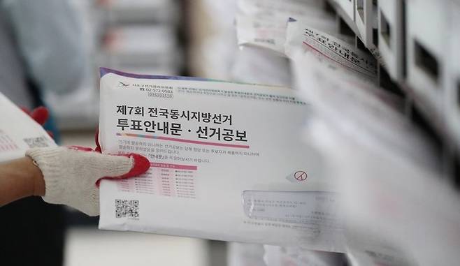 지난 2018년 실시된 제 7회 전국동시지방선거를 앞두고 서울 서초구의 한 아파트에서 집배원이 책자형 선거공보물을 우편함에 배달하고 있다. 연합뉴스 자료사진