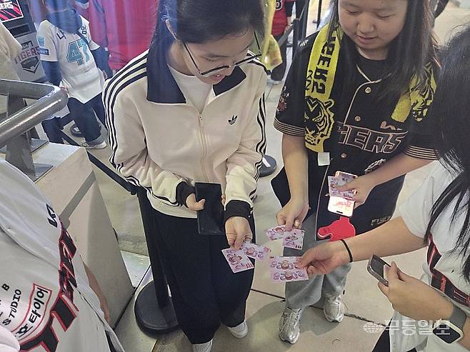 2026 신한 SOL BANK KBO리그 NC 다이노스-KIA 타이거즈 전이 3일 광주-기아 챔피언스 필드에서 진행된 가운데 경기장 내 럭키드로우 현장에서 학생들이 서로 뽑은 포토카드를 선보이고 있다. 박소영기자 psy1@mdilbo.com