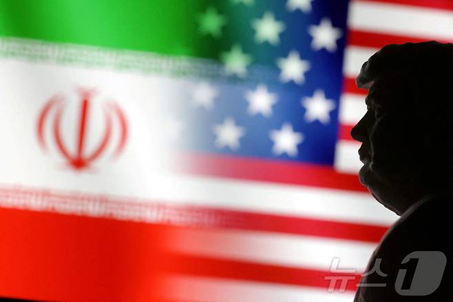 도널드 트럼프 미국 대통령의 형상 뒤로 미국과 이란 국기가 나란히 펼쳐진 모습. 2025.01.15 ⓒ 로이터=뉴스1