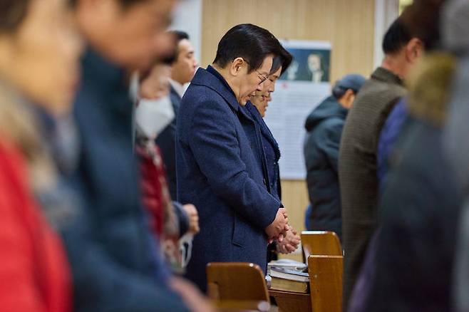 이재명 대통령과 김혜경 여사가 인천 계양구 해인교회에서 열린 성탄예배에 참석해 기도하고 있다. 뉴시스.