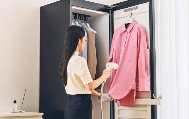 LG 스타일러에 들어 있는 '핸디형 고압 스티머'로 옷의 주름을 제거하고 있다. LG전자 제공